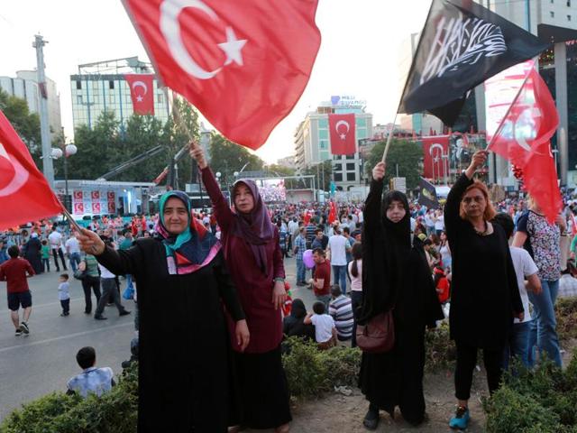 Women wave flags of Turkey as another holds a black flag with Islamic Arabic writing at the Kizilay Square during a protest against the failed military coup. (AFP Photo) Women wave flags of Turkey as another holds a black flag with Islamic Arabic writing at the Kizilay Square during a protest against the failed military coup. (AFP Photo)