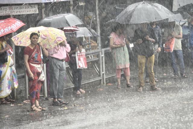 Soaked commuters wait for a bus at Ghatkopar.