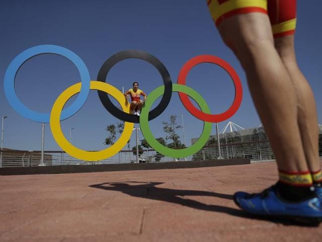 Spanish cyclist Tania Calvo poses for a picture for teammate Juan Peralta on the Olympics rings in the Olympic Park ahead of the 2016 Summer Olympics in Rio de Janeiro, Brazil. (AP Photo) (AP)