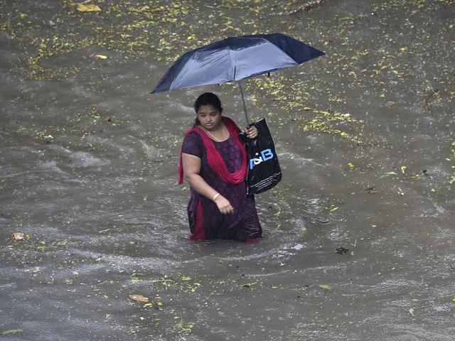 A Woman wades  through flooded water at sion during heavy rains in Mumbai on Friday. (Vijayanand Gupta) 