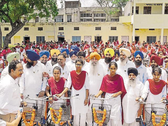 Balbir Singh Ghunas (centre) at the function where he distributed bicycles to government school girls in Mansa, on Thursday.(HT Photo)