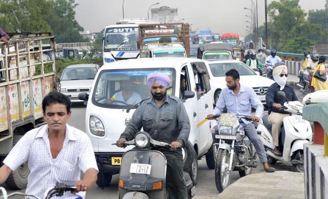 Commuters struck in a traffic jam due to protest at Dholewal bridge in Ludhiana on Friday. (Gurminder Singh/HT Photo)