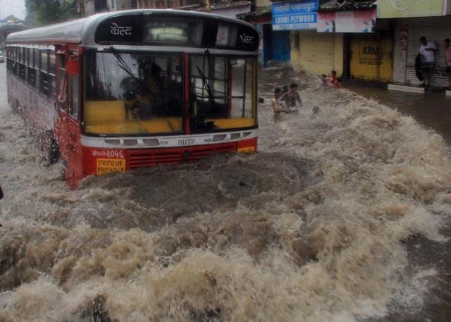 A bus crowls through water logged street at Hindamata after the heavy rain in Mumbai on Friday. (Bhushan Koyande) 