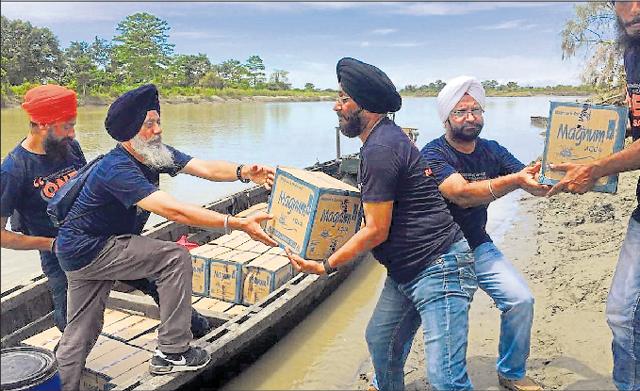 Tajinderpal Singh and Harjeet Singh helping with a relief operation in Assam on Friday.(HT Photo)