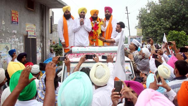 Atop the campaign vehicle, from left, AAP’s Payal segment candidate Gurpreet Singh Lapran, MP Bhagwant Mann, candidate from Sahnewal Harjot Singh Bains and the candidate from Rupnagar, Amarjit Singh, at a road show in Sahnewal constituency in Ludhiana on Saturday. (JS Grewal/HT Photo)