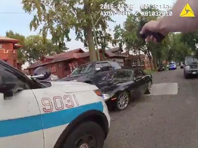 A Chicago police officer is seen shooting his weapon at a moving car (centre) in this still image from a video taken from a body camera released by the Chicago police in Chicago, Illinois. (Reuters Photo) A Chicago police officer is seen shooting his weapon at a moving car (centre) in this still image from a video taken from a body camera released by the Chicago police in Chicago, Illinois. (Reuters Photo)