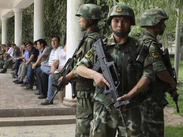 Paramilitary policemen patrol past a building in the Xinjiang Uighur Autonomous Region.(Reuters File) Paramilitary policemen patrol past a building in the Xinjiang Uighur Autonomous Region.(Reuters File)