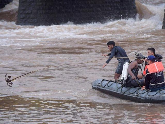 Indian Coast Guard personnel carry out rescue work in Savitri River near the collapsed Mahad bridge on the Mumbai-Goa highway in Raigad district. (PTI) Indian Coast Guard personnel carry out rescue work in Savitri River near the collapsed Mahad bridge on the Mumbai-Goa highway in Raigad district. (PTI)