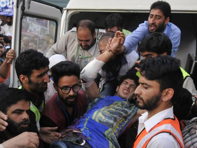 Kashmiri men pelt stones at police during a protest in Srinagar.(Waseem Andrabi/HT Photo)