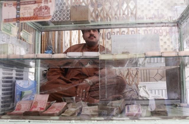 An Afghan money changer waits for customers at the money exchange market in Kandahar south of Kabul, Afghanistan on Sunday. (AP) An Afghan money changer waits for customers at the money exchange market in Kandahar south of Kabul, Afghanistan on Sunday. (AP)