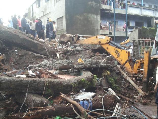 Rescuers remove the rubble of the two-storey building that collapsed early on Sunday killing two people and injuring six others.(Praful Gangurde)