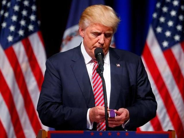 Republican presidential nominee Donald Trump holds a Purple Heart given to him during a campaign event at Briar Woods High School in Ashburn.(Reuters)