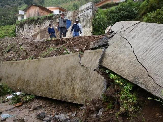 Residents survey the damage from a mudslide following heavy showers caused by the passing of Tropical Storm Earl in the town of Temazolapa.(Reuters)