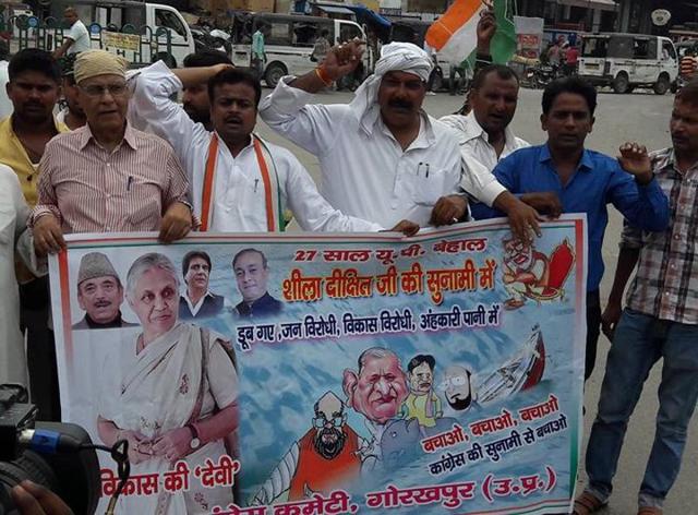 Congress workers with the poster showing Sheila Dikshit as ‘goddess of development’, in Gorakhpur on Sunday.(HT Photo)