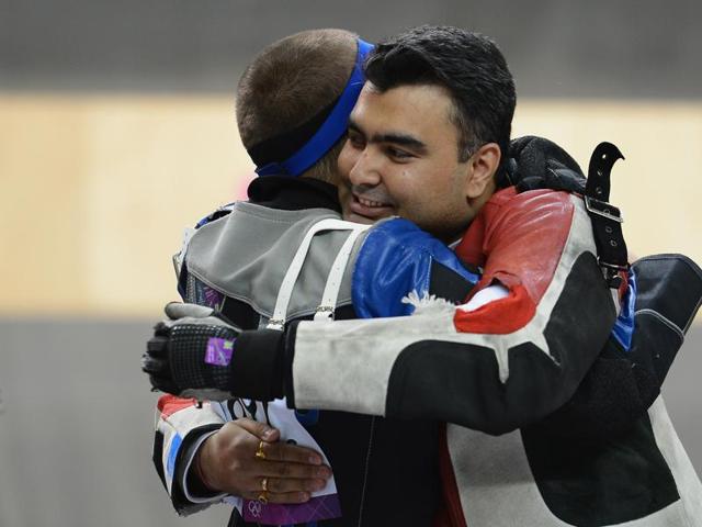 Alin George Moldoveanu of Romania, who won the gold, hugs Gagan Narang , who held onto to win the bronze at The Royal Artillery Barracks. Niccolo Campriani of Italy won silver that day. (Getty Images)