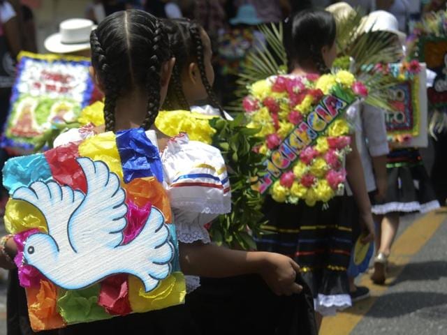 A traditional ’silleterito’ participates in a parade with a ‘silleta’ (flower arrangement) with the theme ‘peace’ in Medellin. (AFP) A traditional ’silleterito’ participates in a parade with a ‘silleta’ (flower arrangement) with the theme ‘peace’ in Medellin. (AFP)