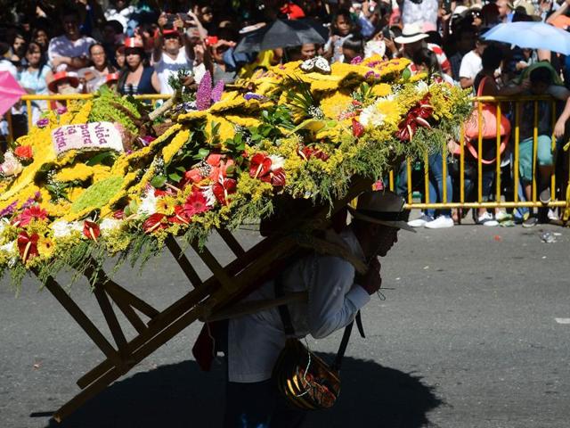 A man carries a flower arrangement during the parade. (AFP) A man carries a flower arrangement during the parade. (AFP)