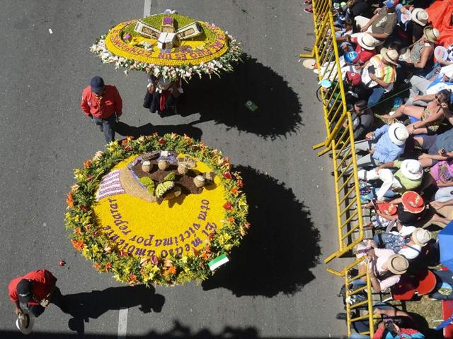 Small farmers carry flower arrangements during the parade. (AFP) Small farmers carry flower arrangements during the parade. (AFP)