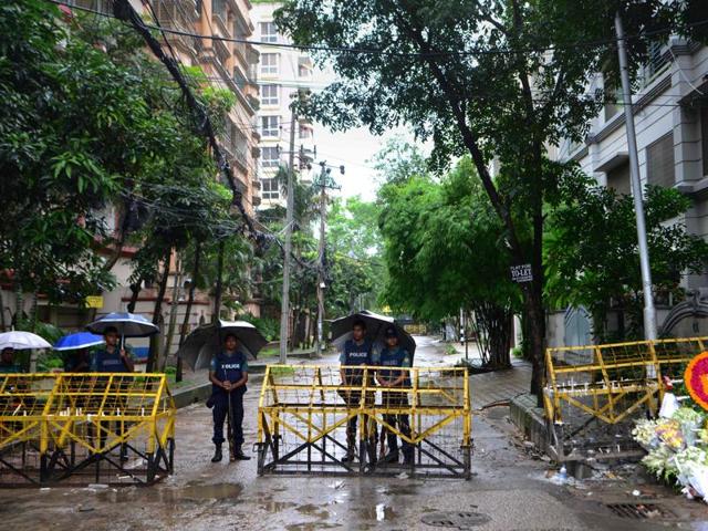 Bangladeshi policemen stand under umbrellas at a checkpoint in Dhaka on July 5, 2016, in a street leading to the entrance of a restaurant where a bloody siege ended in the death of seventeen foreigners and five Bangladeshis.(AFP file photo)