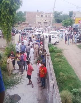 Crowds gathered outside the house where the bodies were found. (HT Photo)