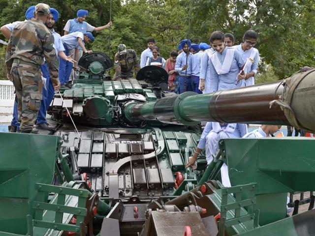 WHAT’S IN THERE? Students atop a tank, checking it out and asking questions, at an army exhibition in Amritsar on Wednesday. (Gurpreet Singh/HT Photo)