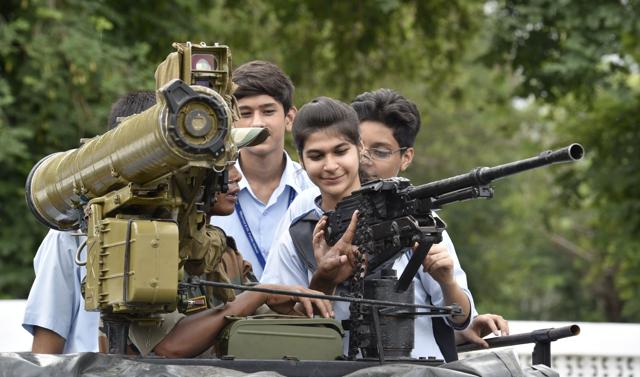 OH, SHOOT! An army personnel tells a girl about a gun at an exhibition in Amritsar on Wednesday. (Gurpreet Singh/HT Photo)