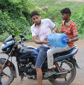 A youth carries a 20-litre jar of water from one of the RO plants in Simri (AP Dube/HT Photo) A youth carries a 20-litre jar of water from one of the RO plants in Simri (AP Dube/HT Photo)