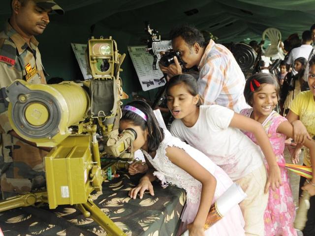 Girls look through a rocket launcher during 'Know Your Army' exhibition. (Subhendu Ghosh/HT Photo) Girls look through a rocket launcher during 'Know Your Army' exhibition. (Subhendu Ghosh/HT Photo)