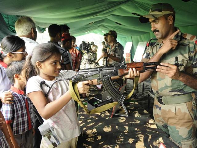 A girl is tries to hold an AK 47 rifle at the 'Know Your Army' exhibition. (Subhendu Ghosh/HT Photo) A girl is tries to hold an AK 47 rifle at the 'Know Your Army' exhibition. (Subhendu Ghosh/HT Photo)