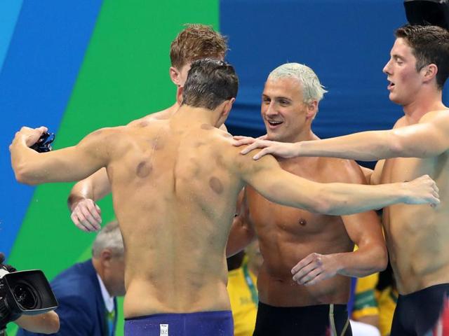 Group hug after the win. Townley Haas (partially hidden), Michael Phelps (back to camera), Ryan Lochte and Conor Dwyer celebrate the 4x200 freestlye win. (AP photo)