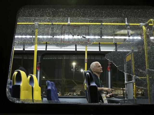 A person sits on an official media bus after a window shattered when driving accredited journalists to the Main Transport Mall from the Deodoro venue of the Rio 2016 Olympic Games in Rio de Janeiro, August 9, 2016.(REUTERS)