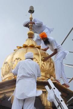 Volunteers cleaning the gold plating of Golden Temple in Amritsar on Thursday. (HT Photos)