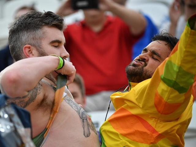 A fan and a volunteer chest bump during the women's beach volleyball match between the Netherlands and Australia. The important question to ask is, why is he lifting his shirt? (AFP)