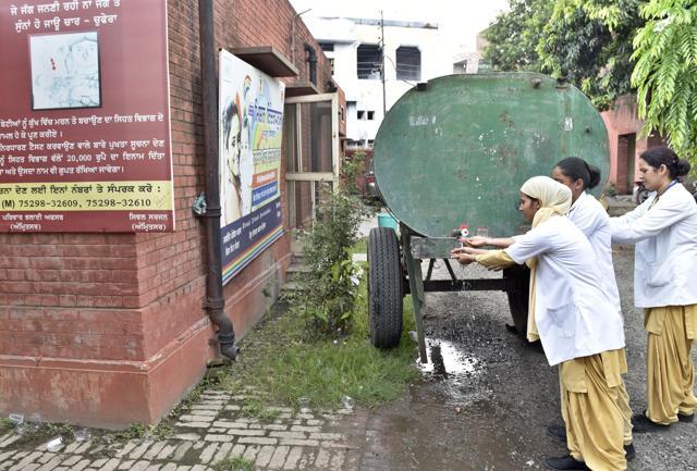 Hospital staff using water from the MC tanker. (Gurpreet Singh/HT Photo)