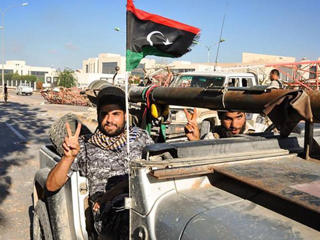 A handout picture uploaded on August 10 on the official Facebook page of the media center of the forces of Libya's Government of National Accord's military operation against the Islamic State group in Sirte shows the forces loyal to Libya's unity government in front of the Ouagadougou conference centre in Sirte after they captured it from the Islamic State group.(AFP)