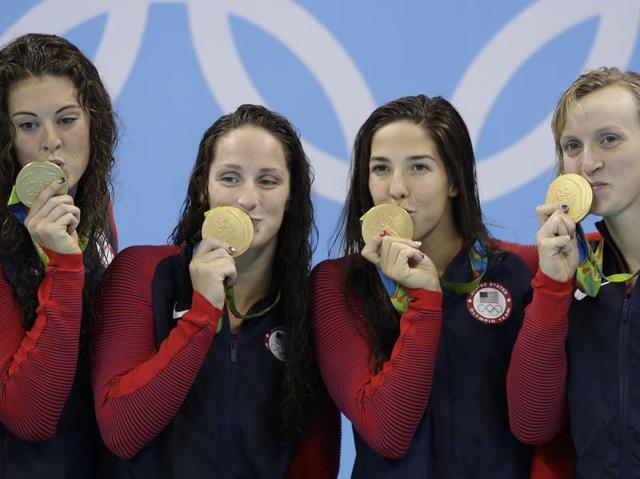 United States' Allison Schmitt, Leah Smith, Maya DiRado and Katie Ledecky, from left, kiss their medals during the women's 4 x 200-meter freestyle relay medals ceremony. (AP Photo) 