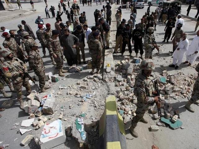 Security officials gather at the site of a bomb explosion in Quetta on Thursday.(REUTERS)