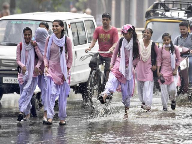 Students walking on the flooded Mall Road in Amritsar on Thursday.(Gurpreet Singh/HT Photo)