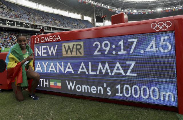 Ethiopia's Almaz Ayana poses next to a scoreboard showing her new world record in the women's 10,000-metre final. (AP)