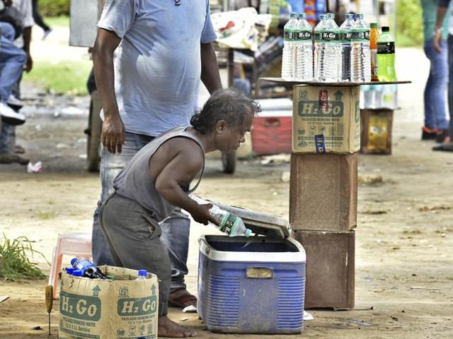 In the morning, the lawns at India Gate attract more unruly students than tourists. Monu occupies himself by selling bottled water, after a quick bath at the fountain area here. (Raj K Raj/HT PHOTO)