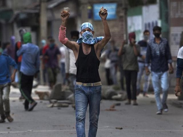 A Kashmiri protester holds stones in his hands as he shouts pro-freedom slogans during a protest in Srinagar.(AP Photo)