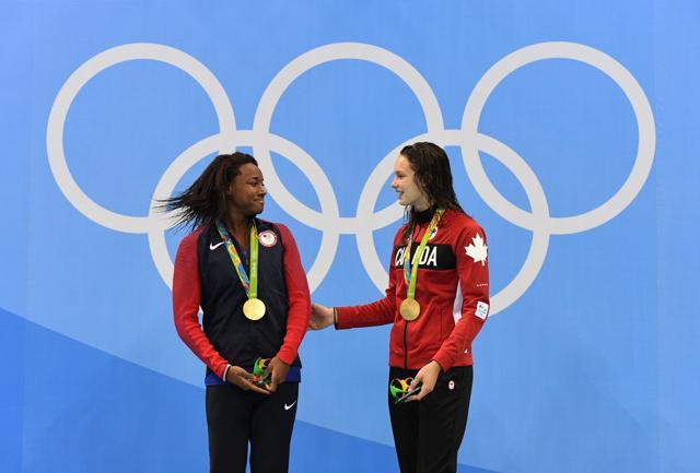 United States' Simone Manuel and Canada's Penny Oleksiak celebrate their tie for gold in the women's 100-meter freestyle. (AP)