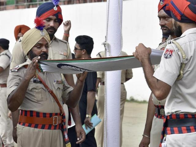 Police officials folding the national flag during the Independence Day rehearsal in Amritsar on Saturday. (Gurpreet Singh/HT Photo)