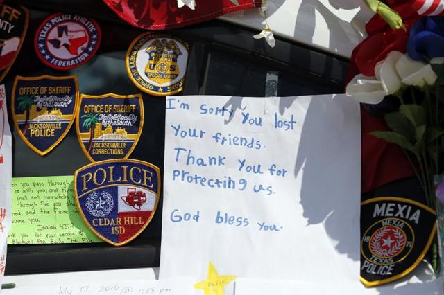 A note left behind attached to a police cruiser at a makeshift memorial in front of the headquarters of the Dallas Police Department sits surrounded by law enforcement badges. (AP Photo) A note left behind attached to a police cruiser at a makeshift memorial in front of the headquarters of the Dallas Police Department sits surrounded by law enforcement badges. (AP Photo)