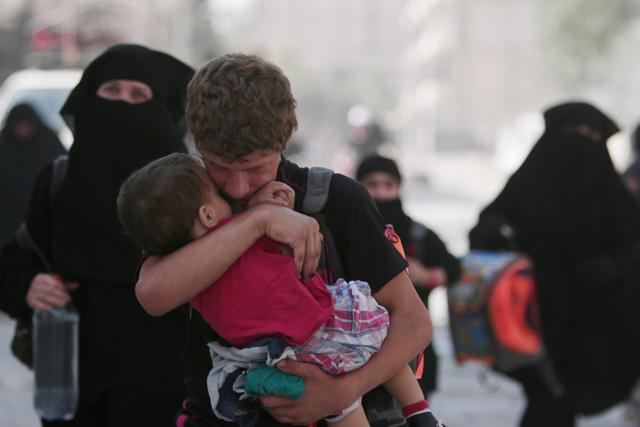A civilian carries a child as he walks with others after they were evacuated by the Syria Democratic Forces (SDF) fighters from an Islamic State-controlled neighbourhood of Manbij. (REUTERS) A civilian carries a child as he walks with others after they were evacuated by the Syria Democratic Forces (SDF) fighters from an Islamic State-controlled neighbourhood of Manbij. (REUTERS)