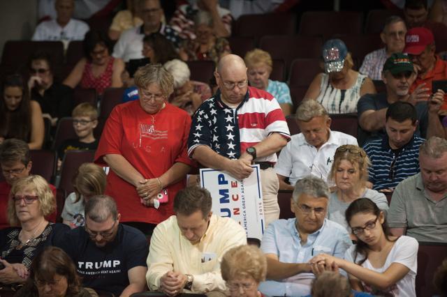 Attendees pray before Donald Trump speaks at a rally at Erie Insurance Arena in Erie, Pennsylvania, on Friday. (AFP)