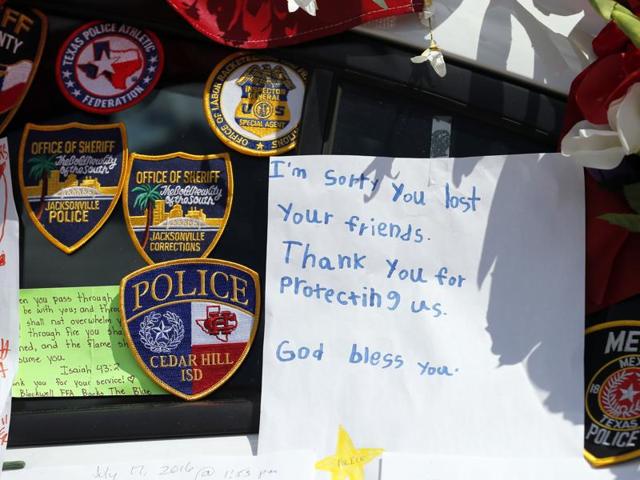 A note left behind attached to a police cruiser at a makeshift memorial in front of the headquarters of the Dallas Police Department sits surrounded by law enforcement badges, Tuesday, July 19, 2016, in Dallas. Five police officers were killed by a gunman during a protest last month in Dallas. (AP) A note left behind attached to a police cruiser at a makeshift memorial in front of the headquarters of the Dallas Police Department sits surrounded by law enforcement badges, Tuesday, July 19, 2016, in Dallas. Five police officers were killed by a gunman during a protest last month in Dallas. (AP)
