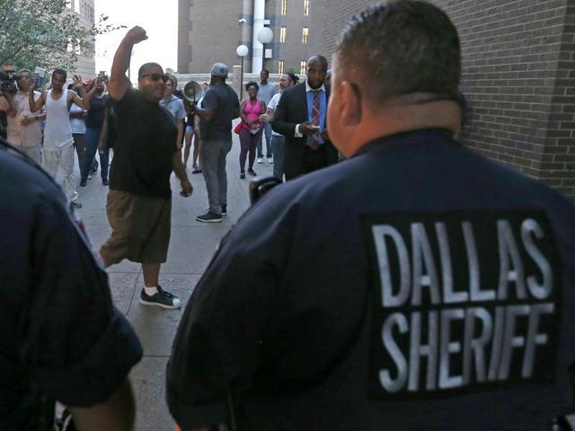 Protesters march by a blue ribbon that honours five fallen police officers killed in the July 7 ambush attack on Main Street in Dallas. (AP Photo) Protesters march by a blue ribbon that honours five fallen police officers killed in the July 7 ambush attack on Main Street in Dallas. (AP Photo)