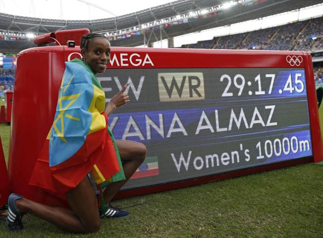 Ethiopia's Almaz Ayana celebrates next to the board displaying her world record in the women's 10,000m at the Olympic Stadium in Rio de Janeiro on Friday.(AFP) Ethiopia's Almaz Ayana celebrates next to the board displaying her world record in the women's 10,000m at the Olympic Stadium in Rio de Janeiro on Friday.(AFP)