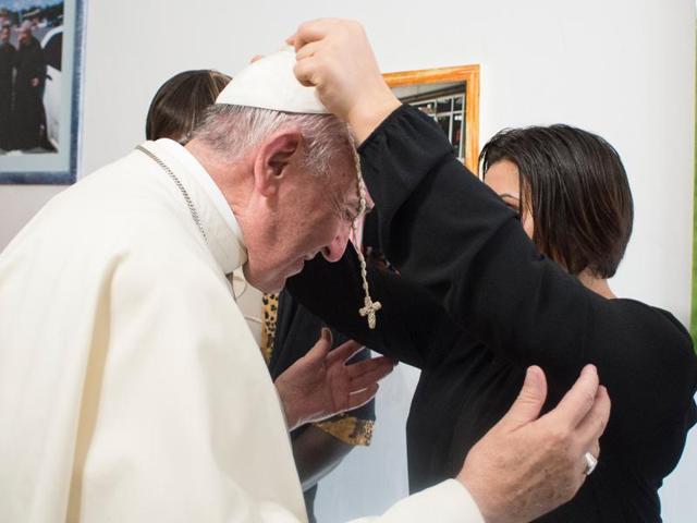 Pope Francis is given a rosary during his visit to the Papa Giovanni XXIII community in Rome on Friday. Francis met with 20 women from six countries who have been freed from prostitution as part of his Holy Year of Mercy activities focusing on communities that have experienced suffering.(AP)